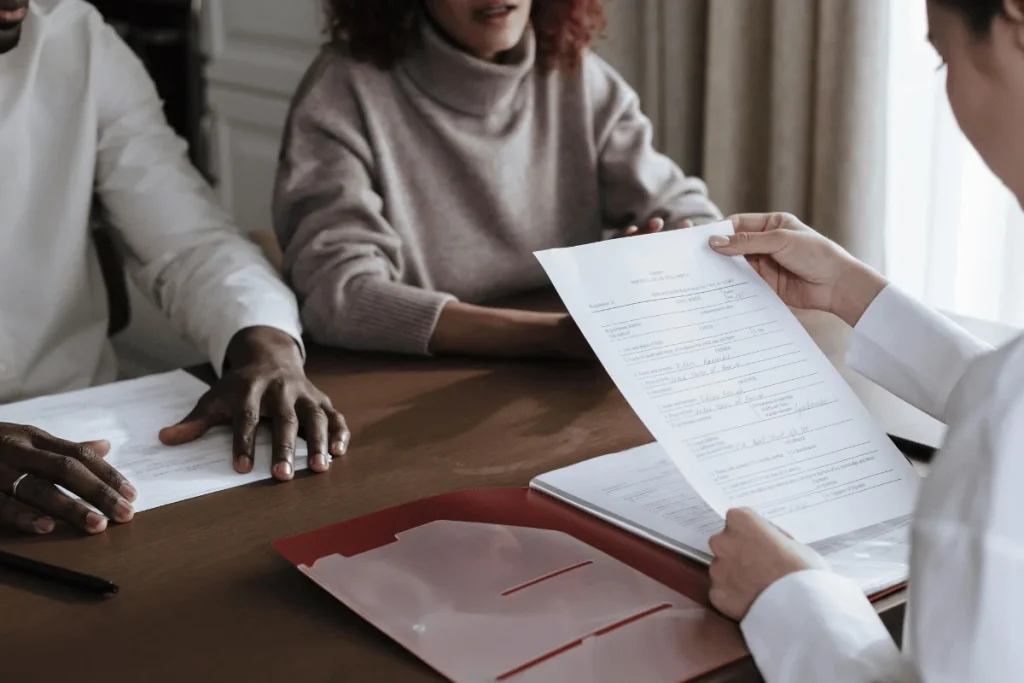 Professional reviewing a document with two people during a meeting.