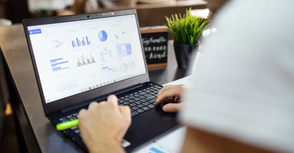 Person reviewing ecommerce financial model dashboard with charts and analytics on laptop screen in office.