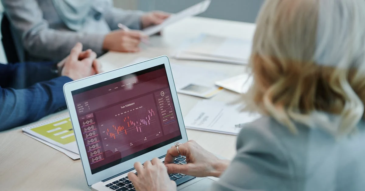 Business professionals analyzing ecommerce cash flow data on laptop during financial planning meeting at table.