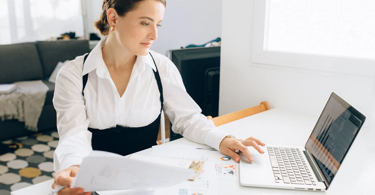 Woman reviewing ecommerce financial model documents and laptop at desk for revenue forecasting analysis.