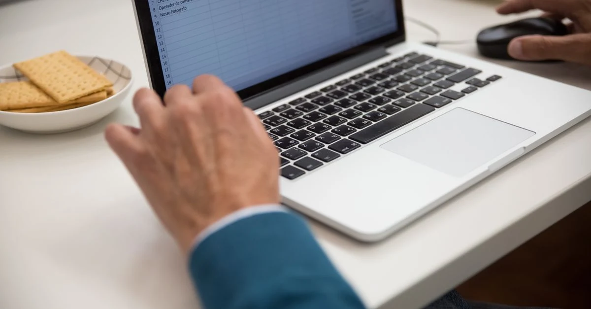 Person using ecommerce analytics tools on laptop at desk with snacks and mouse nearby.