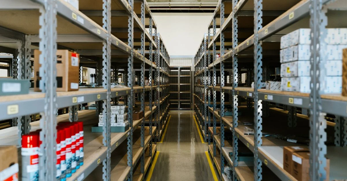 Warehouse shelves stocked with inventory boxes showing ecommerce cash flow management and order fulfillment operations.