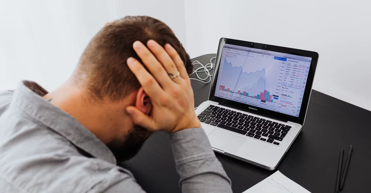 Frustrated person analyzing ecommerce marketing analytics data on laptop dashboard screen at desk.