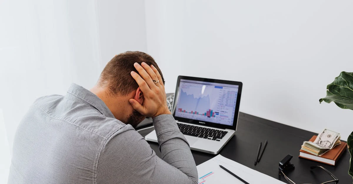 Frustrated ecommerce founder reviewing financial model data on laptop at desk with charts and analytics.
